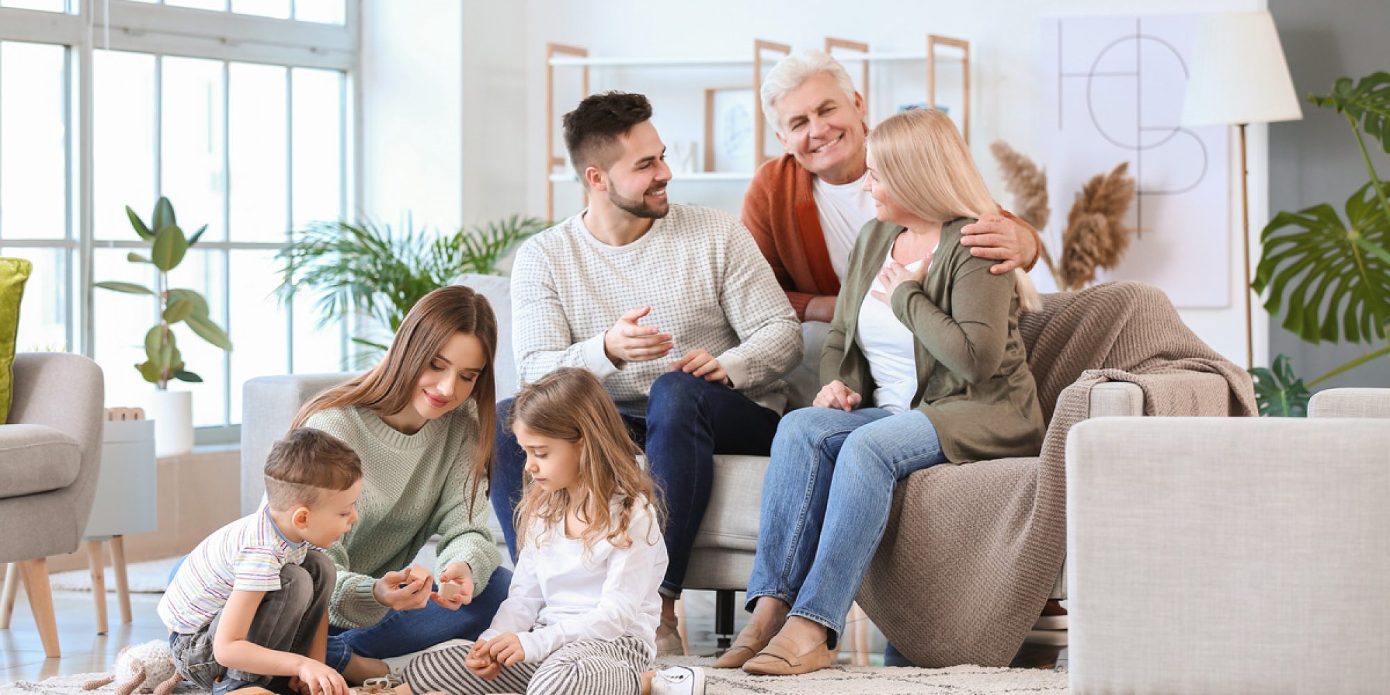 A family sitting on a couch in a Las Cruces home.