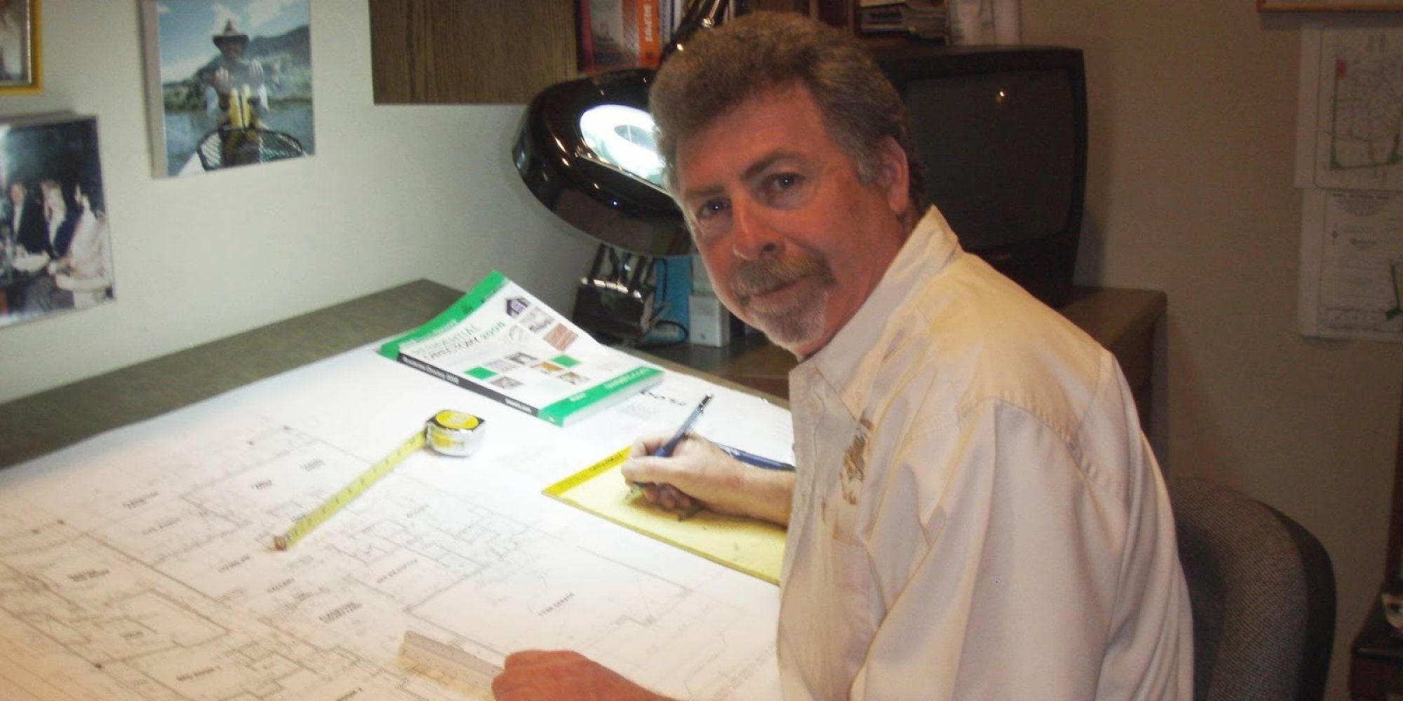 Judd Singer sitting at his drafting desk, working on a new floor plan